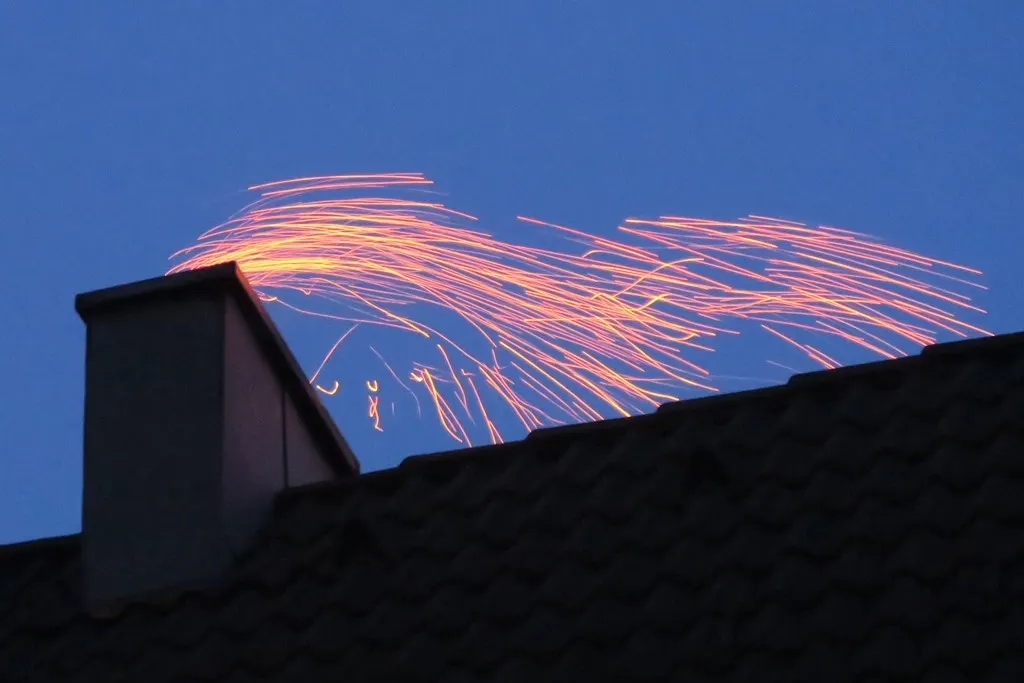 Sparks streaming from a chimney top during a chimney fire