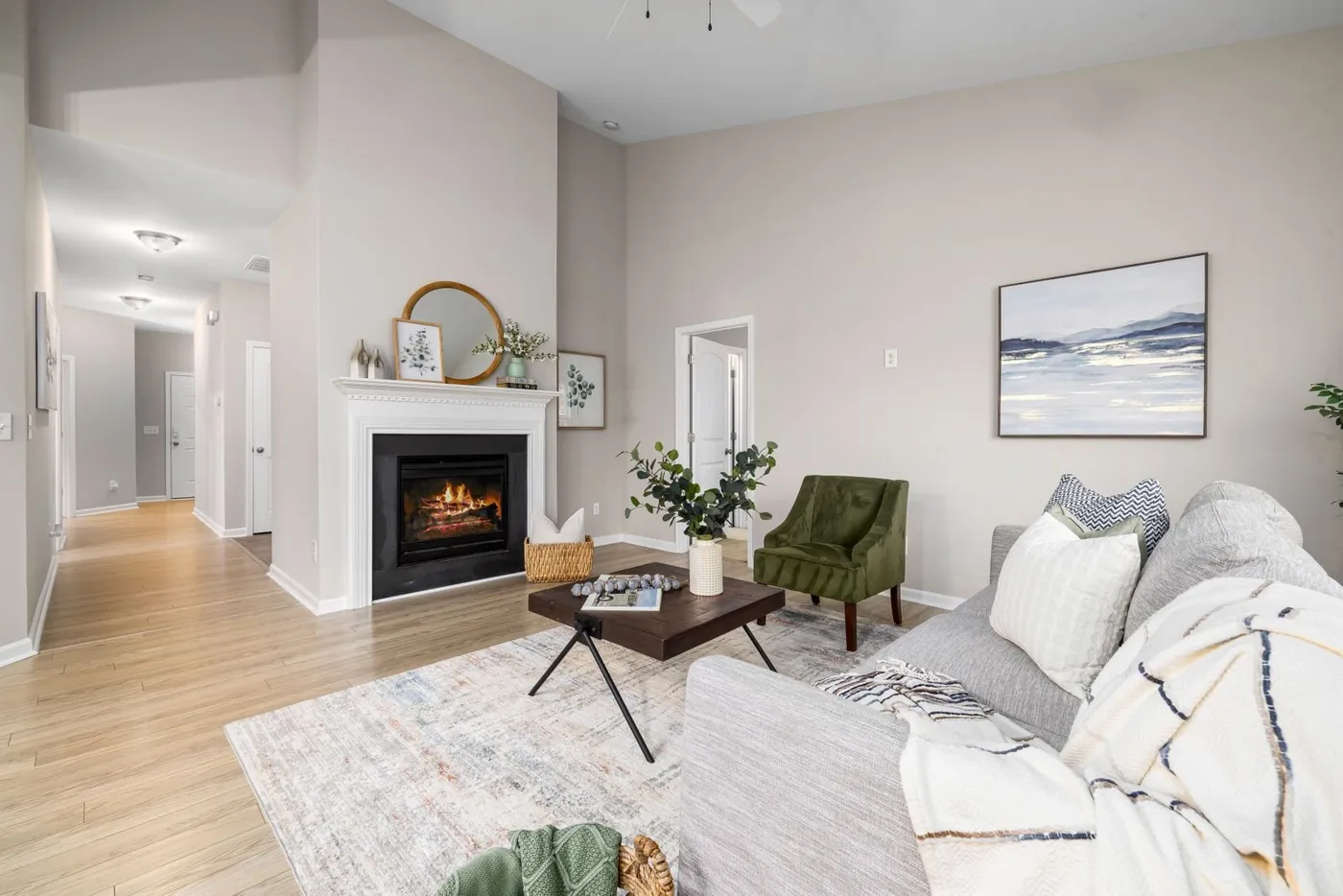 Lit fireplace with a white mantel in a bright living room