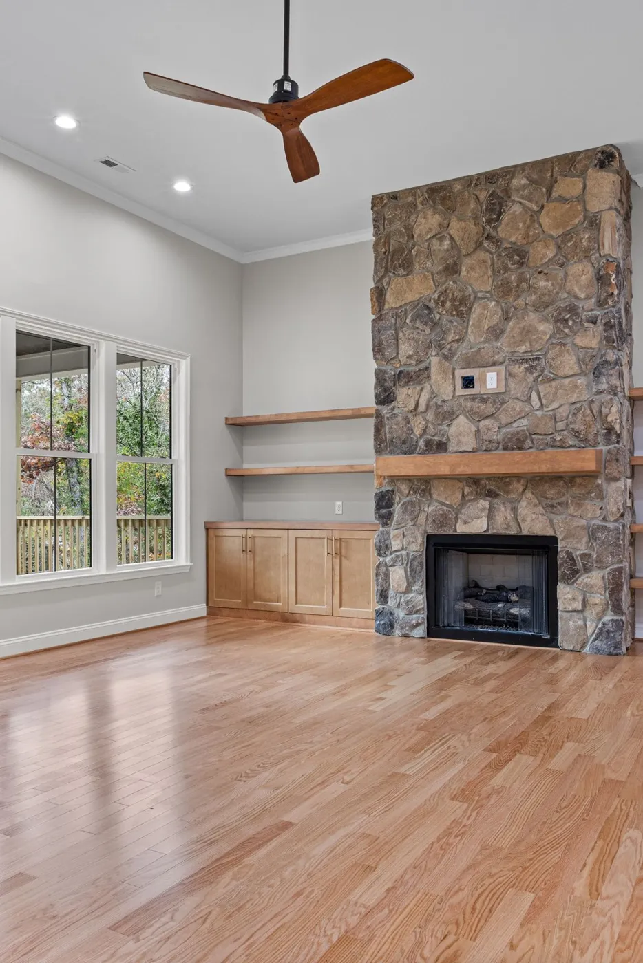 Floor-to-ceiling fieldstone fireplace in a new living room